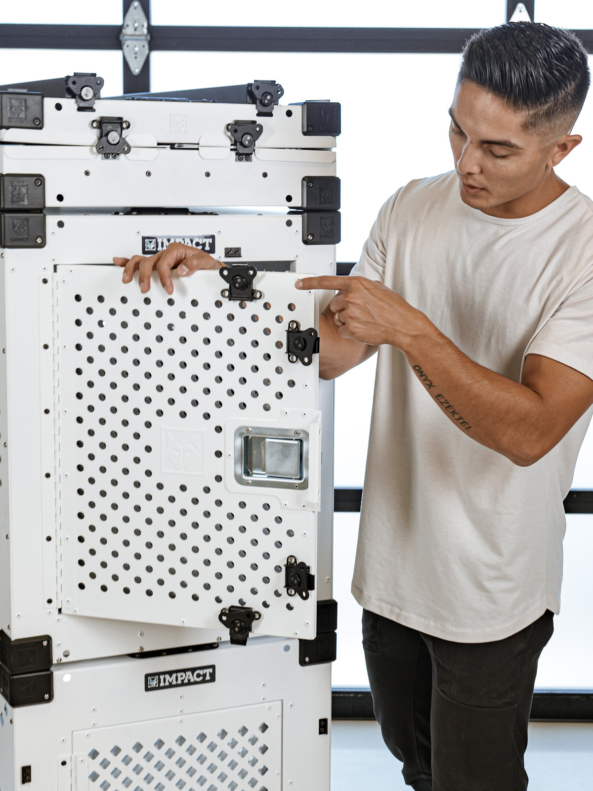 a man pointing to the butterfly latches on a high anxiety crate highlighting the features on the high anxiety crate