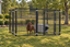 10x10 kennel with a brown dog and gray dog shelter in a yard #size_10x10