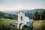 white dog on a green collapsible crate in the mountains